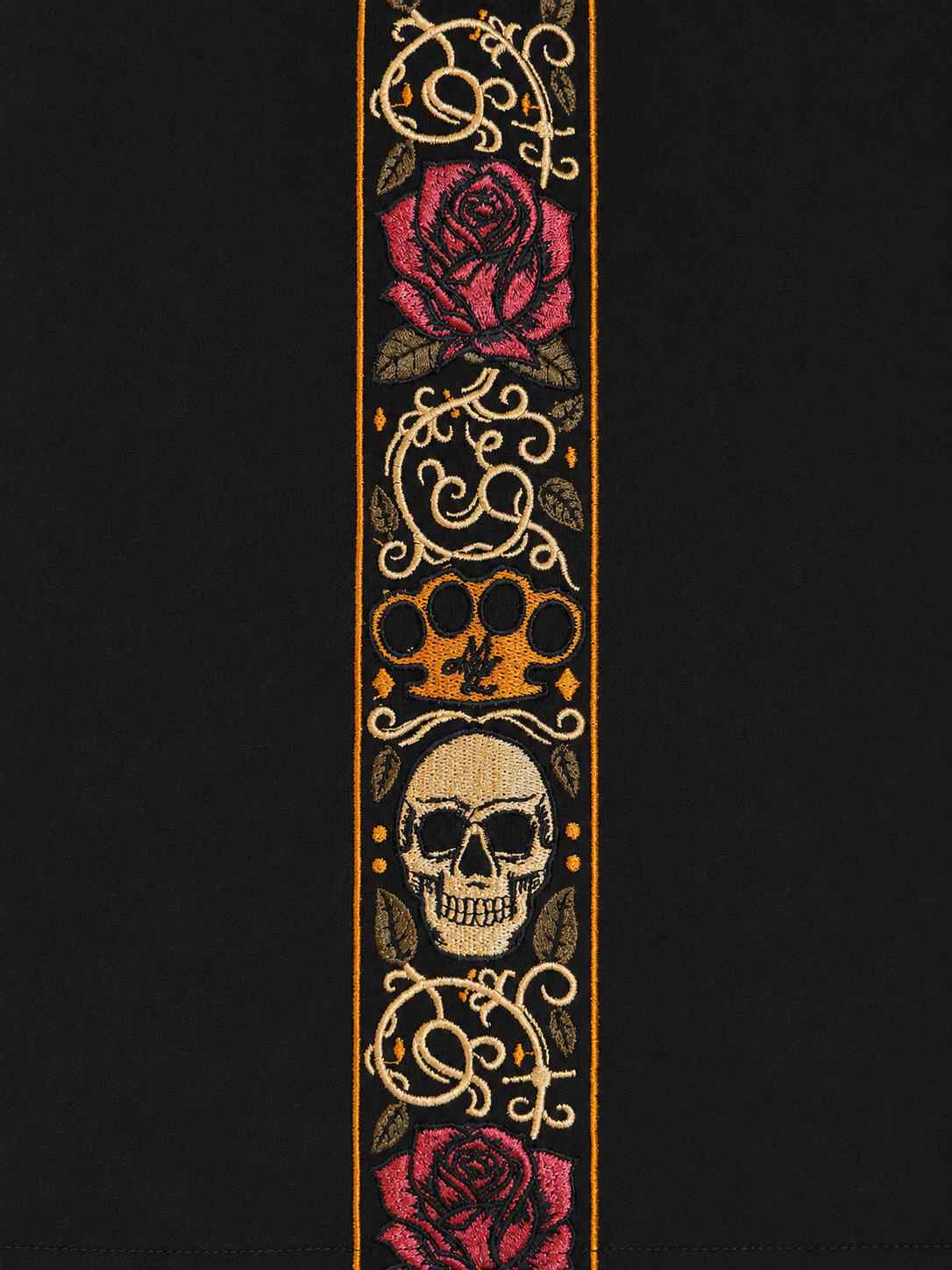 Close-up van de Calavera borduurband met rozen, schedel en MVL logo in goud en rood op zwart