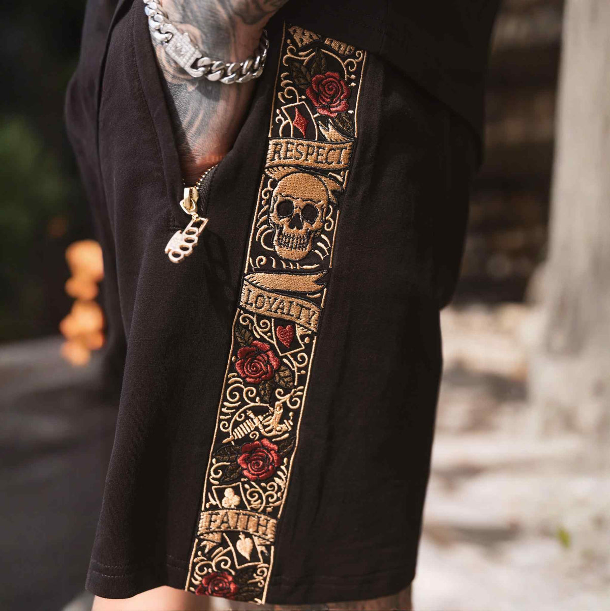Nahaufnahme des LFR Stickbands mit Totenkopf, Rosen, Respect, Loyalty und Faith auf den Jogger-Shorts