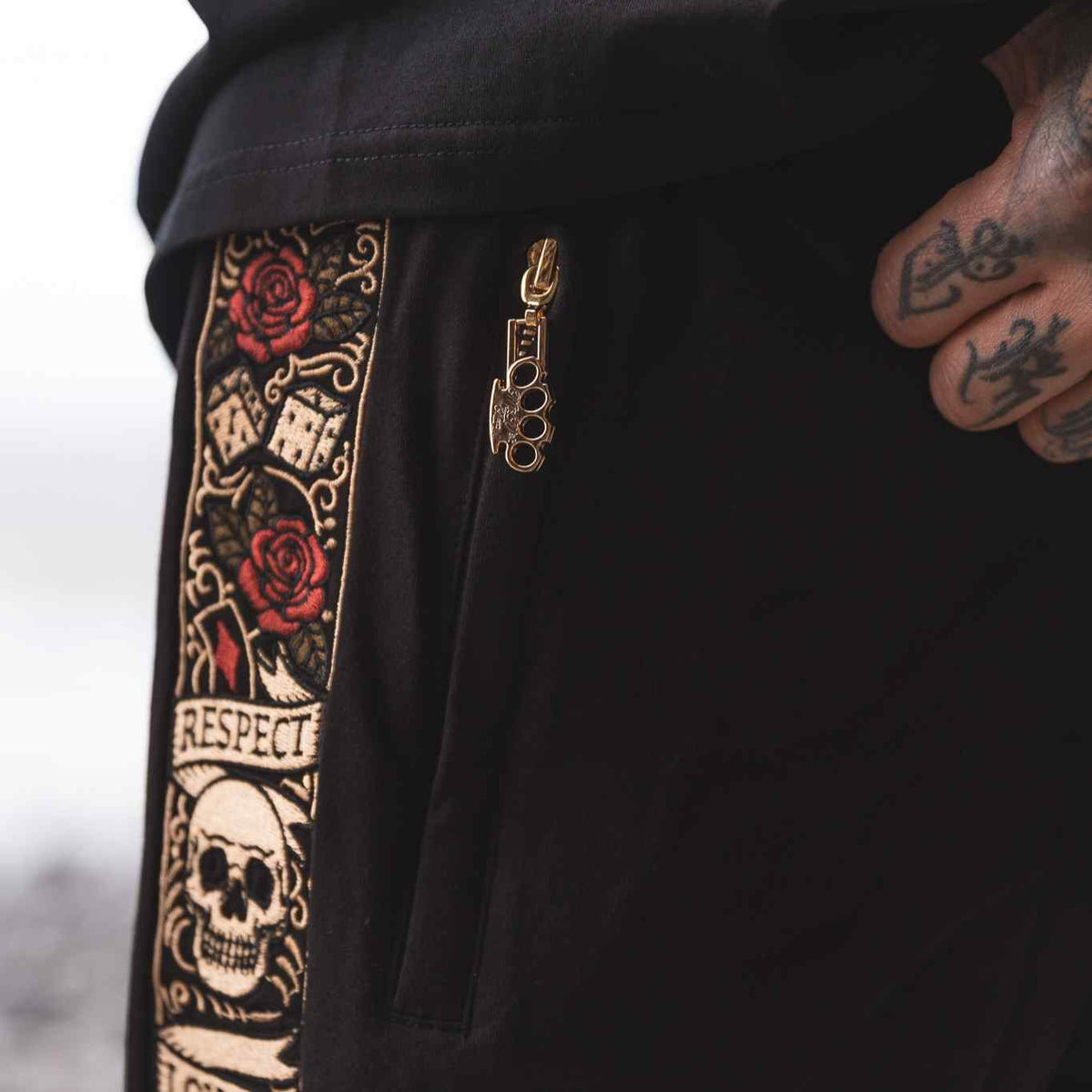 Detail der LFR Jogger-Shorts schwarz: Reißverschluss mit goldenem MVL-Logo-Anhänger neben dem Stickband