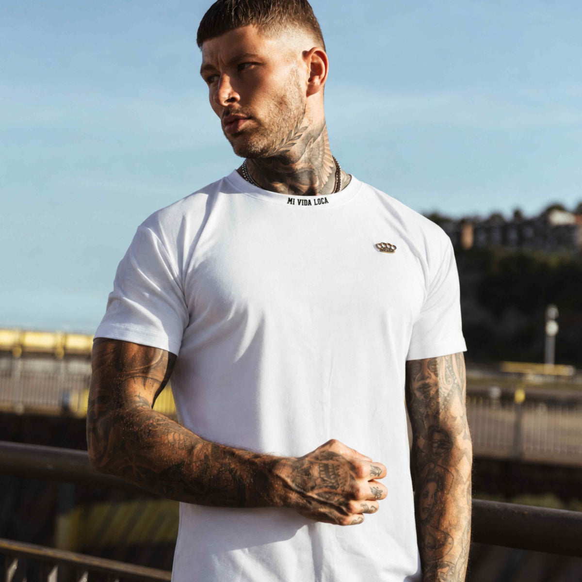 Modello nella T-shirt MVL Winning bianca, vista frontale con logo dorato sul petto