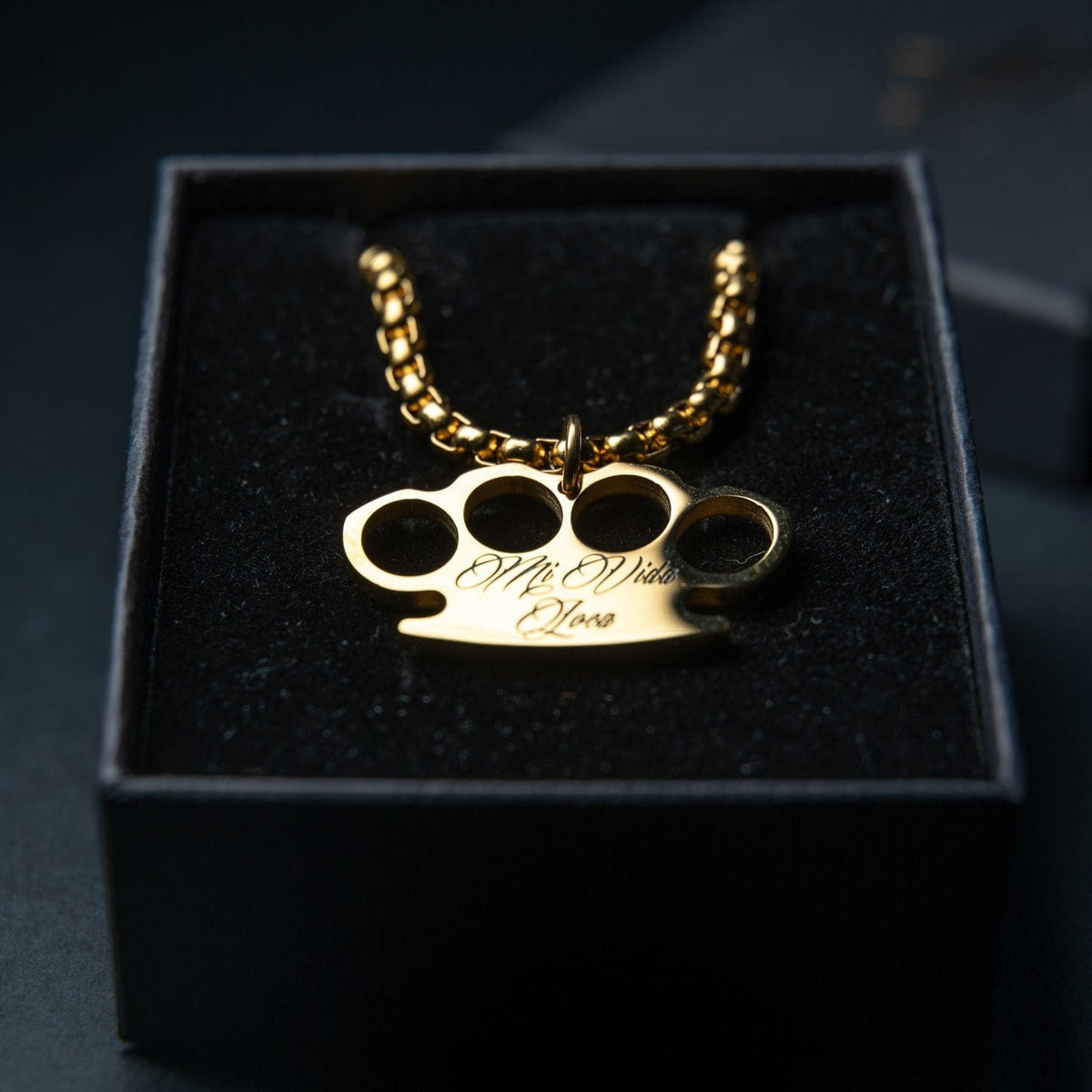 Cadena Mi Vida Loca MVL Logo dorada con colgante del logo MVL dorado grabado, en la caja de regalo negra
