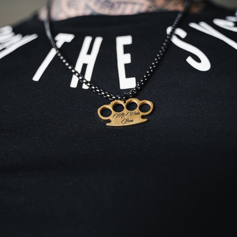 Zwarte MVL Logo chain met gouden MVL logo hanger gedragen op een zwart T-shirt
