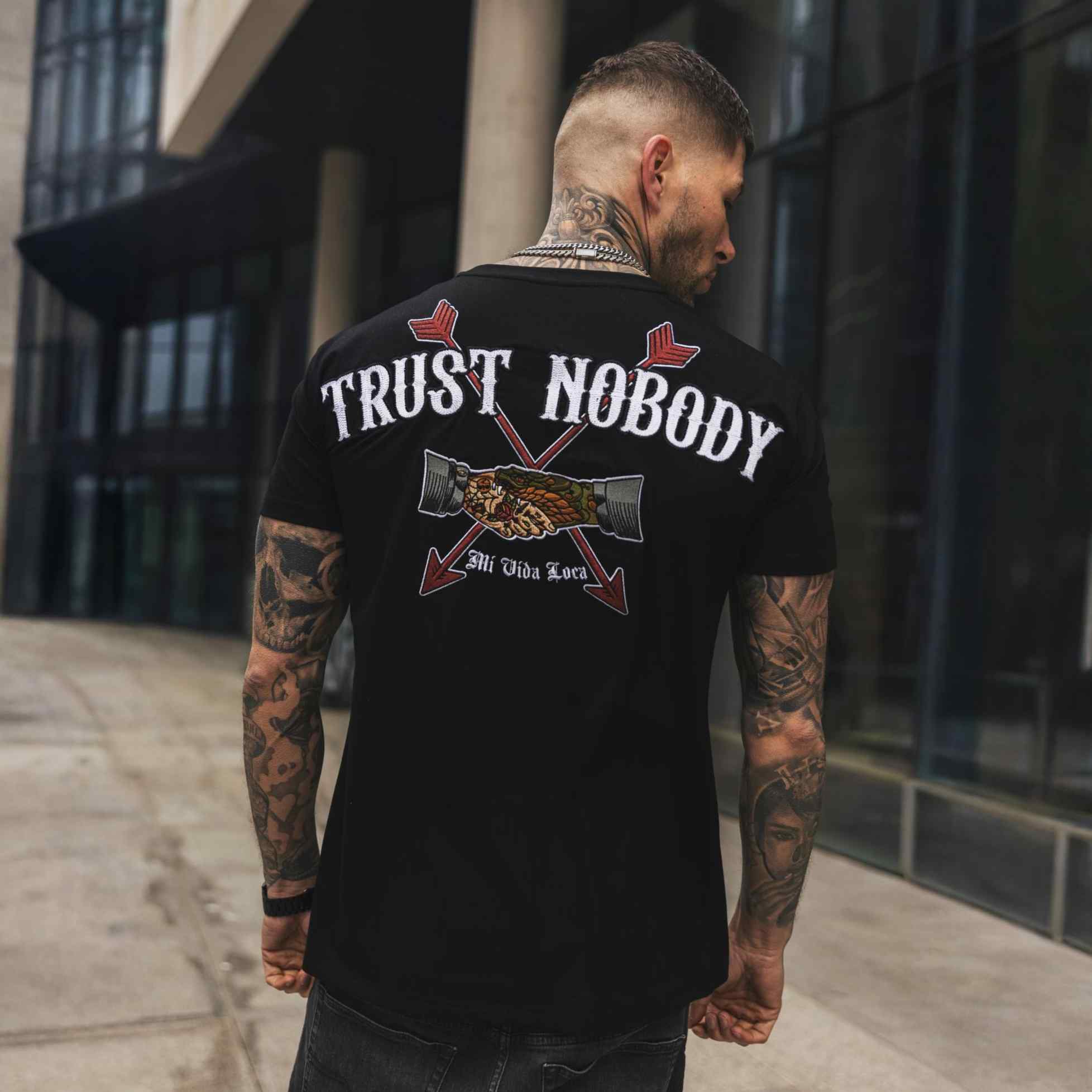 Camiseta negra con el bordado «No confíes en nadie»