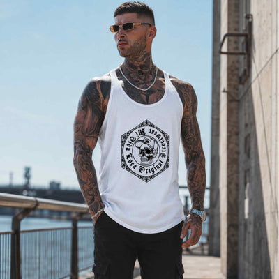 Model met tattoos en zonnebril draagt de witte MVL Original streetwear tanktop aan het water